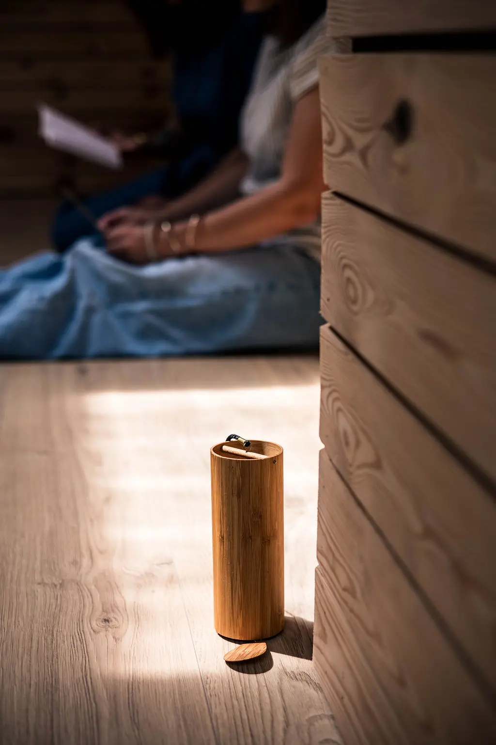 Objet en bois posé au sol, dans la lumière, pendant une journée de transmission